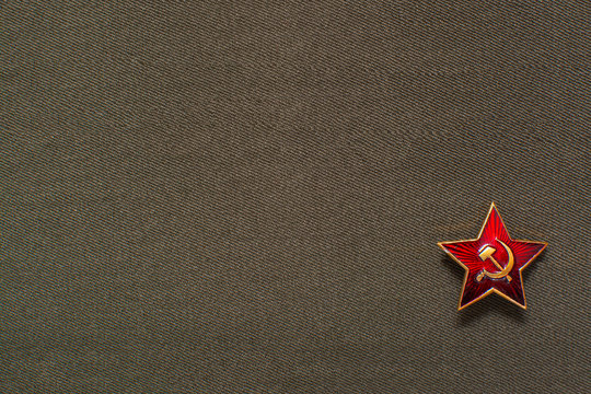 Military soviet star with hammer and sickle on fabric background