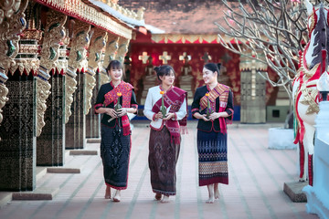 Naklejka premium Three Thai girl In the Phu Thai tribe Standing in the Thai temple area