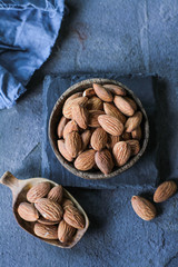 Photo of almond in wooden bowl on dark background. Top view of almond. Almond with wooden spoon or scoop. Almond concept. Images.