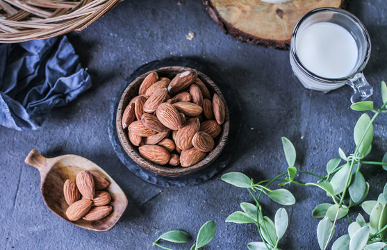 Photo of almond in wooden bowl on dark background. Top view of almond. Almond with wooden spoon or scoop. Almond concept. Images.