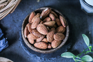 Photo of almond in wooden bowl on dark background. Top view of almond. Almond with wooden spoon or scoop. Almond concept. Images.