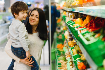 woman and child boy during family shopping with trolley at supermarket