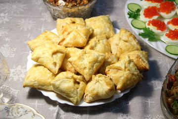 Square cakes on plate on holiday table among others dishes