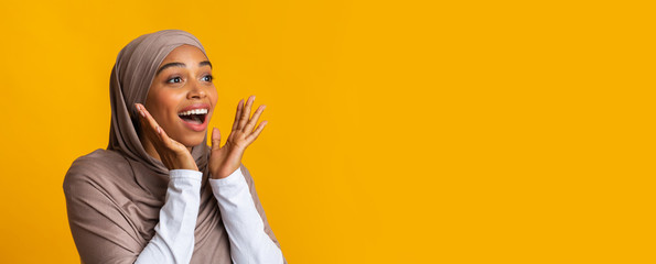 Portrait of dazed black muslim girl in hijab over yellow background