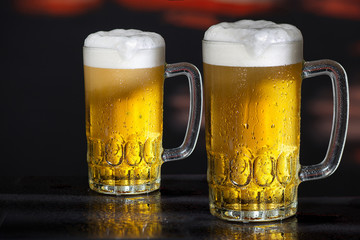 Two glasses of beer on the dark background