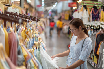 Asian women choose to buy clothes in the wholesale market of clothing in department stores.
