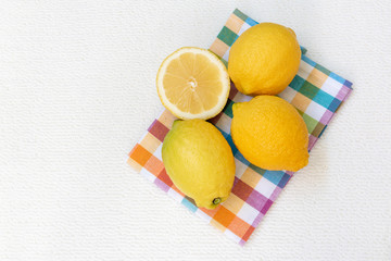 Tres limones y medio sobre un paño de cocina colorido