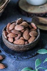 Photo of almond in a wooden bowl. Front View of almond. Almond with wooden spoon or scoop. Raw almond on the table. On rustic board. Images