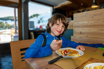 Child eating a steak with french fries