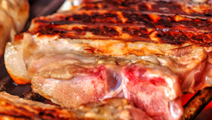 Grilling fresh meat on barbeque close up view