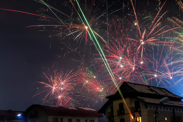 Fireworks over the snowy roofs on New Year's Eve