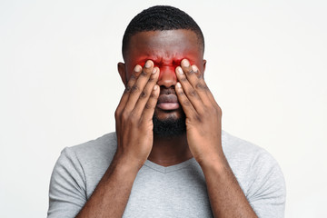 Overworked black guy suffering from eye pain