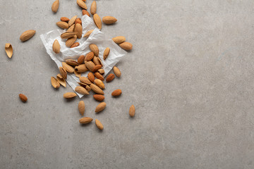 Fototapeta na wymiar Organic almond nuts top view on gray background