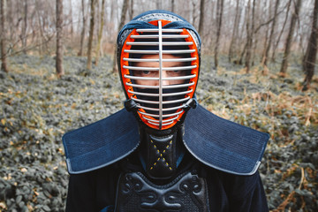 Portrait of man kendo fighter on forest background. Place for text or advertising