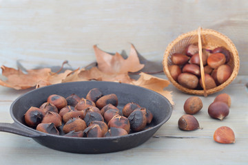 Chestnuts or maroni int on a black frying pan. Roasted Chestnuts close-up, xmas food concept.