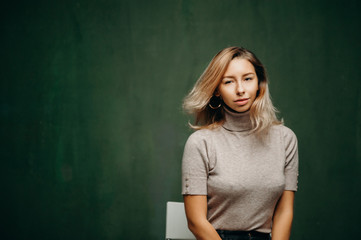 Indoor portrait of beautiful young woman with shaggy hairstyle, looking to camera
