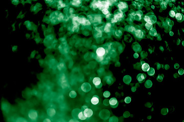 Abstract green bokeh with black background defocused.