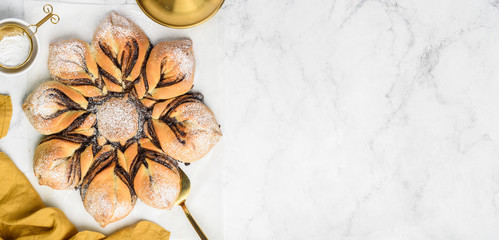 Chocolate twisted star bread on a marble background. Copy space for text. Top view
