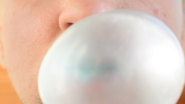 man blowing chewing gum bubble