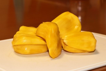 Ripe Jackfruit on white tray and brown background. Sweet & sour tropical fruit.