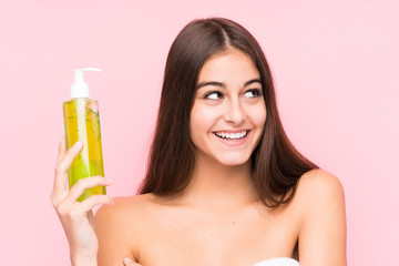 Fototapeta premium Young caucasian woman holding a moisturizer with aloe vera isolated smiling confident with crossed arms.