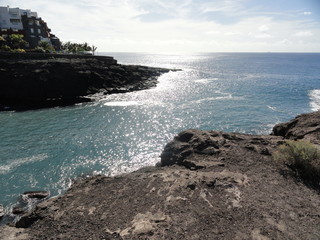 scenery hotels on the rugged coastline and the glare of the sun on the sea, Tenerife