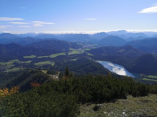 Obraz premium Rolling hills with a lake with cloud reflections on it