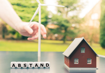 Symbol für den Mindestabstand zwischen Windkraftanlagen und Wohnsiedlungen