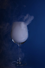 Large wine glasses with smoke on a blue background. Color of the year 2020, Classic Blue.