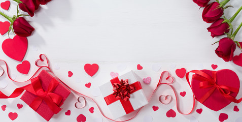 Gift boxes, ribbon hearts and roses on white table. Valentine's day gift concept