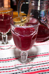Two glass goblets with bloody red liquid and a jug