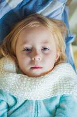 little girl 5 years old with symptoms of a cold in bed