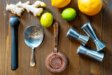 Set of a bartender accessories with fruits and ginger roots on a dark wooden table