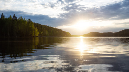 Beautiful sunset above the lake with bright clouds and sky. Kolovesi National park. Finland.