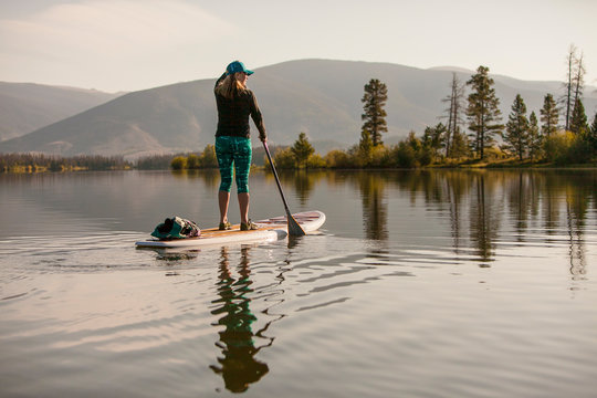 A female paddlboarder on Lake Dillon in Summit County, Colorado in the early morning.