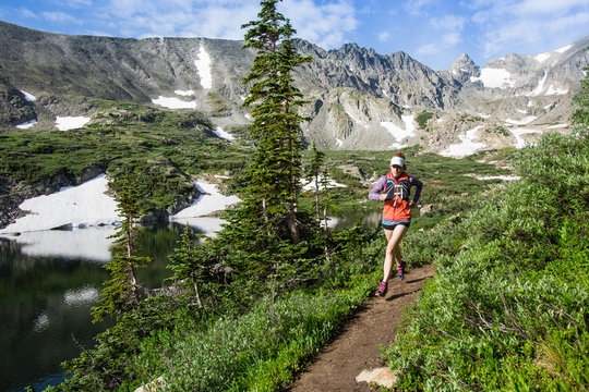      Two women trail running to the high alpine lake. Lake Isabel is part of Brainard Lake Recreation Area outside of Nederland, Colorado.