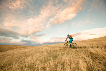 One woman enjoys the first rideable window over Jones Pass on the Continental Divide Trail in Colorado. As the snow melts off the high alpine trails, rocky singletrack is revealed on the Rocky Mountains for a short window before winter hides them under her blanket again.