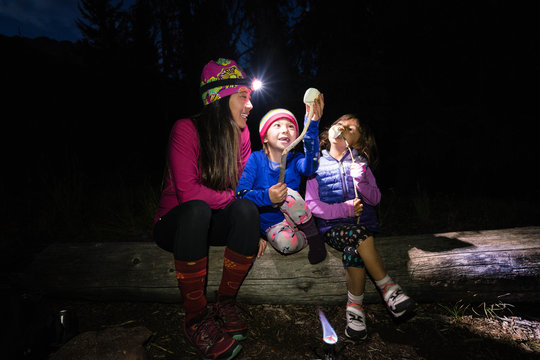 Family whiddling sticks to roast marshmallows while backpacking in the Gore Range, Colorado