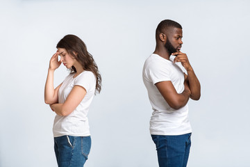 Pensive man and woman standing back to back after quarrel