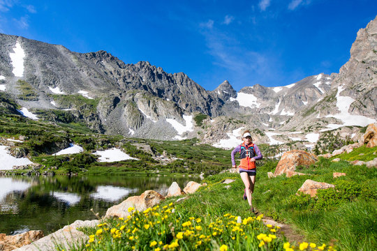       Two women trail running to the high alpine lake. Lake Isabel is part of Brainard Lake Recreation Area outside of Nederland, Colorado.