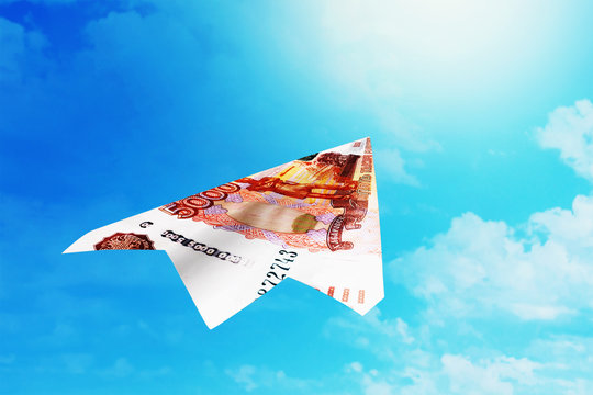 Paper airplane made of russian money on sky background. Concept on the theme of currency growth