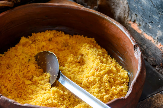 Typical brazilian farofa in old and used clay pot ready to be served