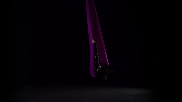 Woman gymnast performing on violet silk in circus stage. Exciting acrobatic show. Slow motion. 146