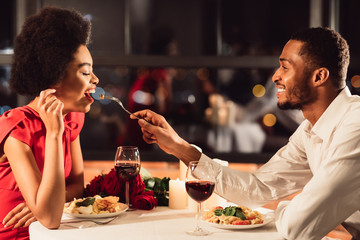 African American Man Feeding Girlfriend Celebrating Anniversary In Restaurant