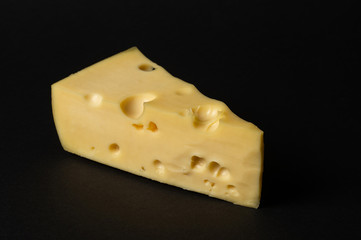 Piece of cheese isolated on a black. background