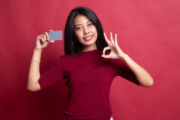 Young Asian woman show OK with a blank card.