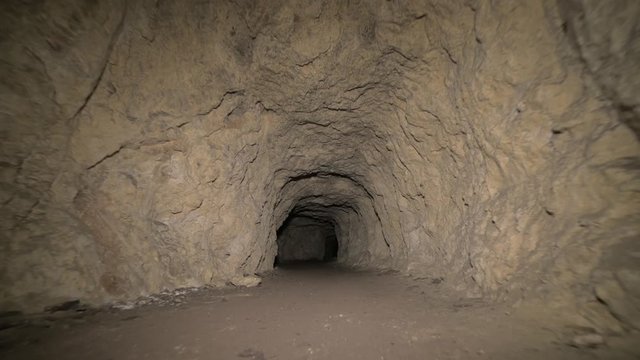 Speleology artificial cave dark tunnel excavation underground. Old adit for the extraction of metal and rocks