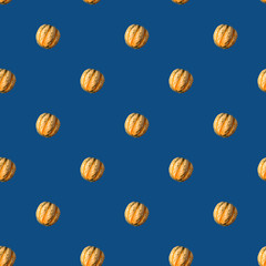 Seamless Pattern made with yellow pumpkin over trendy classic blue color background.