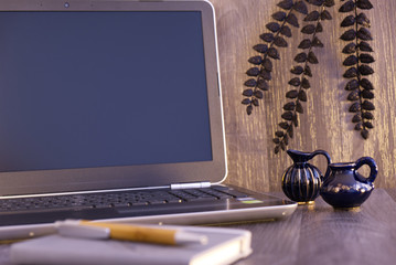 computer on the table with vase and plant
