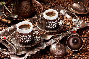 Traditional Turkish coffee in traditional copper cups on  dark table